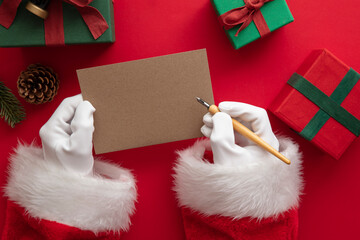 Santa Claus wiring a festive message on blank paper