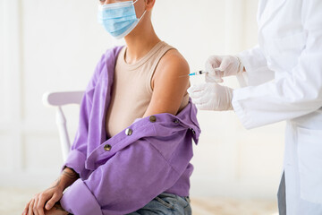 Antiviral immunization. Nurse making coronavirus vaccine injection shot, injecting woman for...