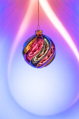 Fototapeta premium Christmas colorful ball hanging on a blue-purple background. Festive Christmas and New Year background with copy space. Banner