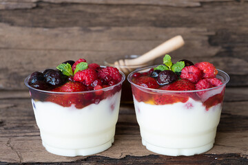 Fruit yogurt has strawberry raspberry blueberry canberry and honey greek white clean In bowl on a wooden background from top view.

