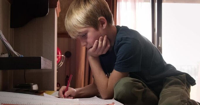 Kid doing homework in his room with his older brother helping. 