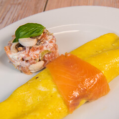 Omelette with salmon and tomatoes, served on plate, traditional Norwegian dish