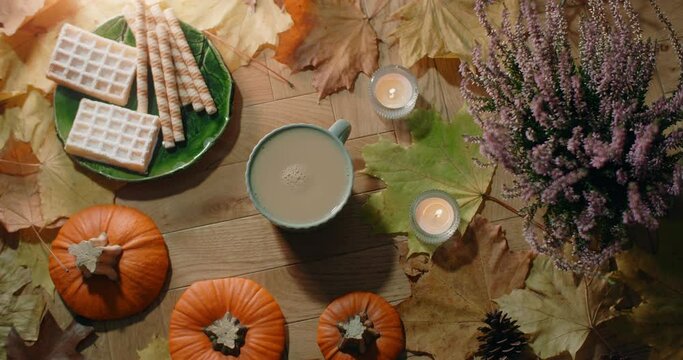 Tabletop video of decorated autumn composition in warm atmosphere with waffles, leaves and tea with milk, 4k 60p Prores HQ