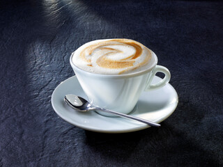 Cappuccino mit Löffel auf Granituntergrund