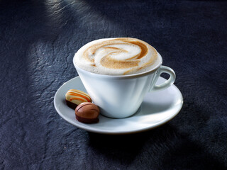 Cappuccino mit Pralinen auf Granituntergrund