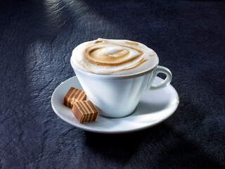 Cappuccino mit Nougat-Praline auf Granituntergrund