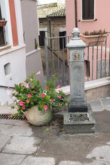iron fountain near vase with flowers