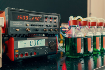 Experimental setup for enzymatic synthesis by genetically modified bacteria in a microbiological laboratory. Cell culture flasks and measuring instruments