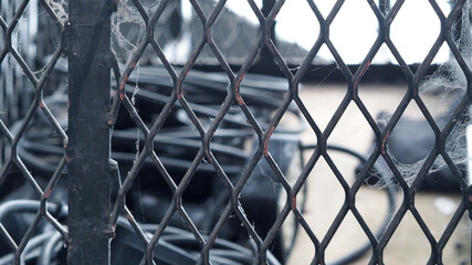 Old Fence and spider cobweb in close up. White cobweb on the old and dirty steel metal fence close-up angle.  