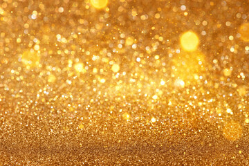 Blurred defocused bokeh background with Christmas lights and golden glitter sparkles