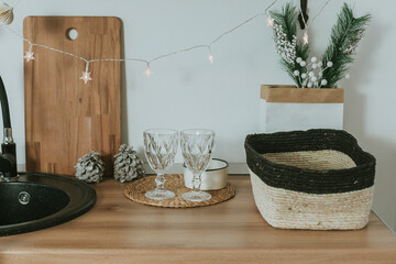 Two glasses, cutting board, decoration on kitchen table desk Garland decor for christmas holiday