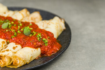 Brazilian pancakes with chicken, tomato bolognese sauce, rolled pancakes.