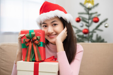 Fototapeta na wymiar Happy beautiful Asian woman celebrate with stacking many present gift box in christmas party. Cute girl in christmas holiday holding gift box decorated with ribbon and bow. Happy new year festival.