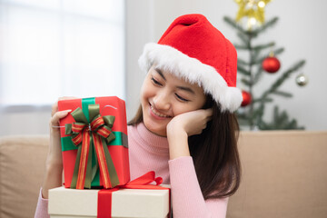 Fototapeta na wymiar Happy beautiful Asian woman celebrate with stacking many present gift box in christmas party. Cute girl in christmas holiday holding gift box decorated with ribbon and bow. Happy new year festival.