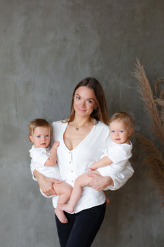 Mother with one year old twins in her hands.