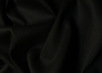 Black crumpled or wavy fabric texture background. Abstract linen cloth soft waves. Creases of...