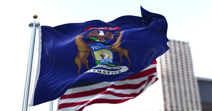 the flag of the US state of Michigan waving in the wind with the American flag blurred in the background
