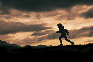 Child in silhouette while running