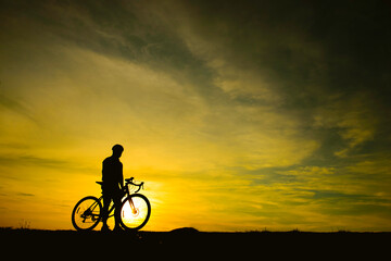 Fototapeta na wymiar Silhouette of handsome man riding bicycle on sunset,sport man concept,Fill flare effect