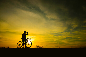 Fototapeta na wymiar Silhouette of handsome man riding bicycle on sunset,sport man concept,Fill flare effect