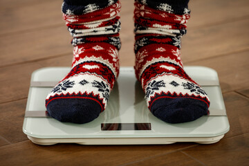 Christmas calories, legs on weight in Christmas socks, diet, overweight 