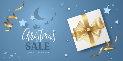Naklejka premium Blue background for Christmas sale banner with text, gold ribbons, bow, stars, 3D gift box and Santa's sleigh flying around the moon. Vector festive template for flyers of discount or special offers.