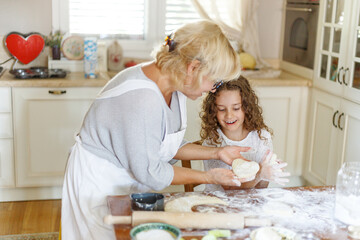 Loving grandmother and her niece are preparing bakery together, having fun moments on the kitchen.