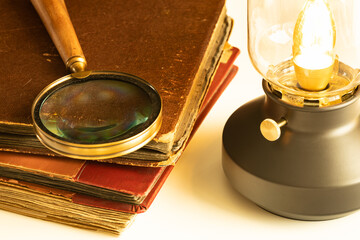 Old albums lying on the desk with a magnifying glass and a stylish lamp shining, Concept of shared...