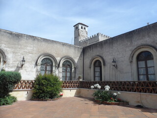 Fototapeta na wymiar Entrada de hacienda antigua con largos ventanales, balcón y torre al fondo
