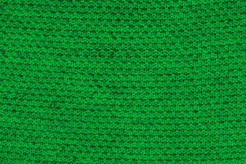 Green knitted fabric texture. Rough sweater background