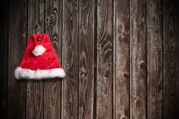 Obraz na płótnie Canvas Christmas Santa Claus Hat Hanging On Wood Wall
