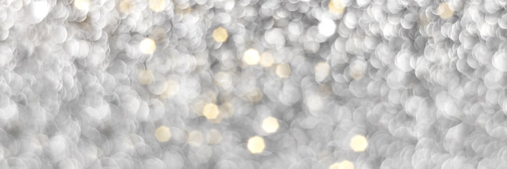 Obraz premium Silver and golden sparkling glitter bokeh background, christmas texture. Holiday lights. Abstract defocused header. Wide screen wallpaper. Panoramic web banner with copy space for design