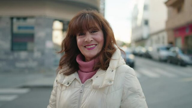 Middle age redhead woman smiling confident standing at street
