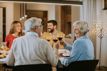 Happy family having dinner with red wine at home