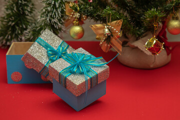 gifts with blue bow, with a Christmas tree in the background