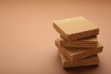 Square chocolate wafer biscuits on brown background.
