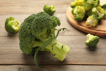 Bunch of fresh green broccoli on cutting board on grey wooden background.