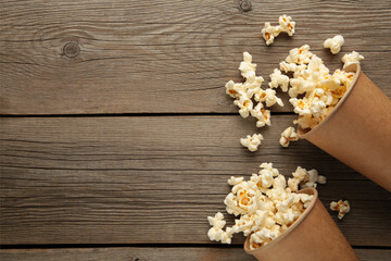 Popcorn in brown cups. Two cups of popcorn on grey wooden background. Sweet popcorn.