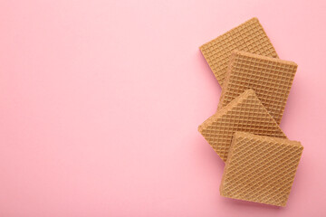 Square chocolate wafer biscuits on pink background.
