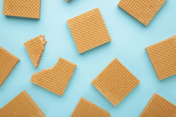 Square chocolate wafer biscuits on blue background.