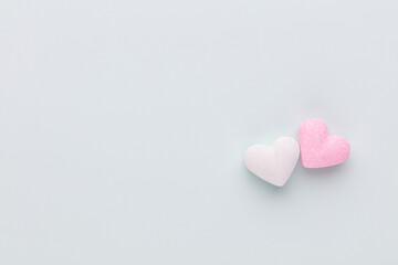 Composition with candy hearts on pastel blue background.