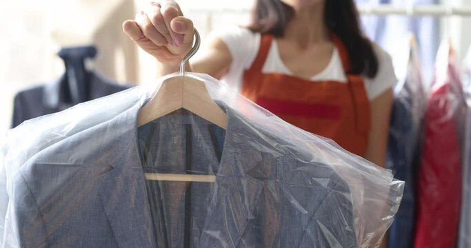 Woman administrator gives out suit from dry cleaner slow motion 4k movie