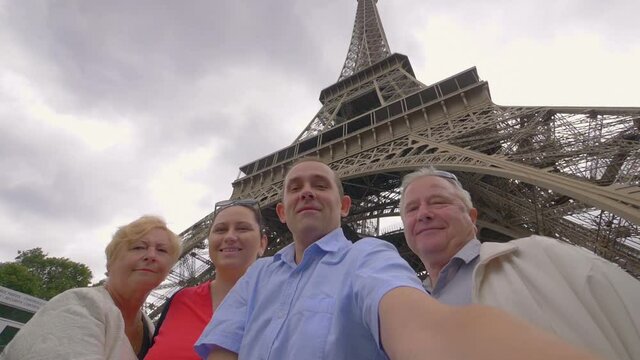 Happy family having fun and sending greetings under the Eiffel Tower in Paris in slow motion 180fps