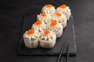 Baked rolls on the board with black  chopsticks. Delicious asian food.