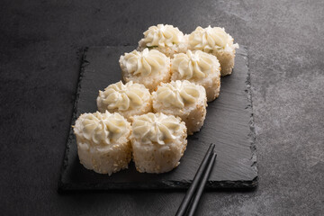 Baked rolls on the board with black  chopsticks. Delicious asian food.