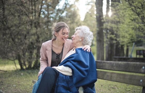 young woman hugging with her grandmother in the park