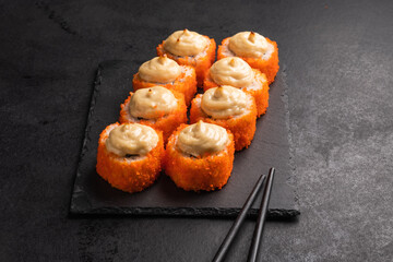 Baked rolls on the board with black  chopsticks. Delicious asian food.