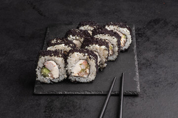 Tasty Japanese food rolls with fish and avocado on black background. Sushi menu.