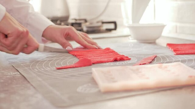 pastry chef makes mastic to decorate cake. Elastic dough, delicious pastries, cooking process. Home production, hobbies, entrepreneurship. knitted lace cuts with knife