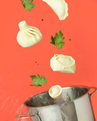 Manty and khinkali fly out of the pan red background